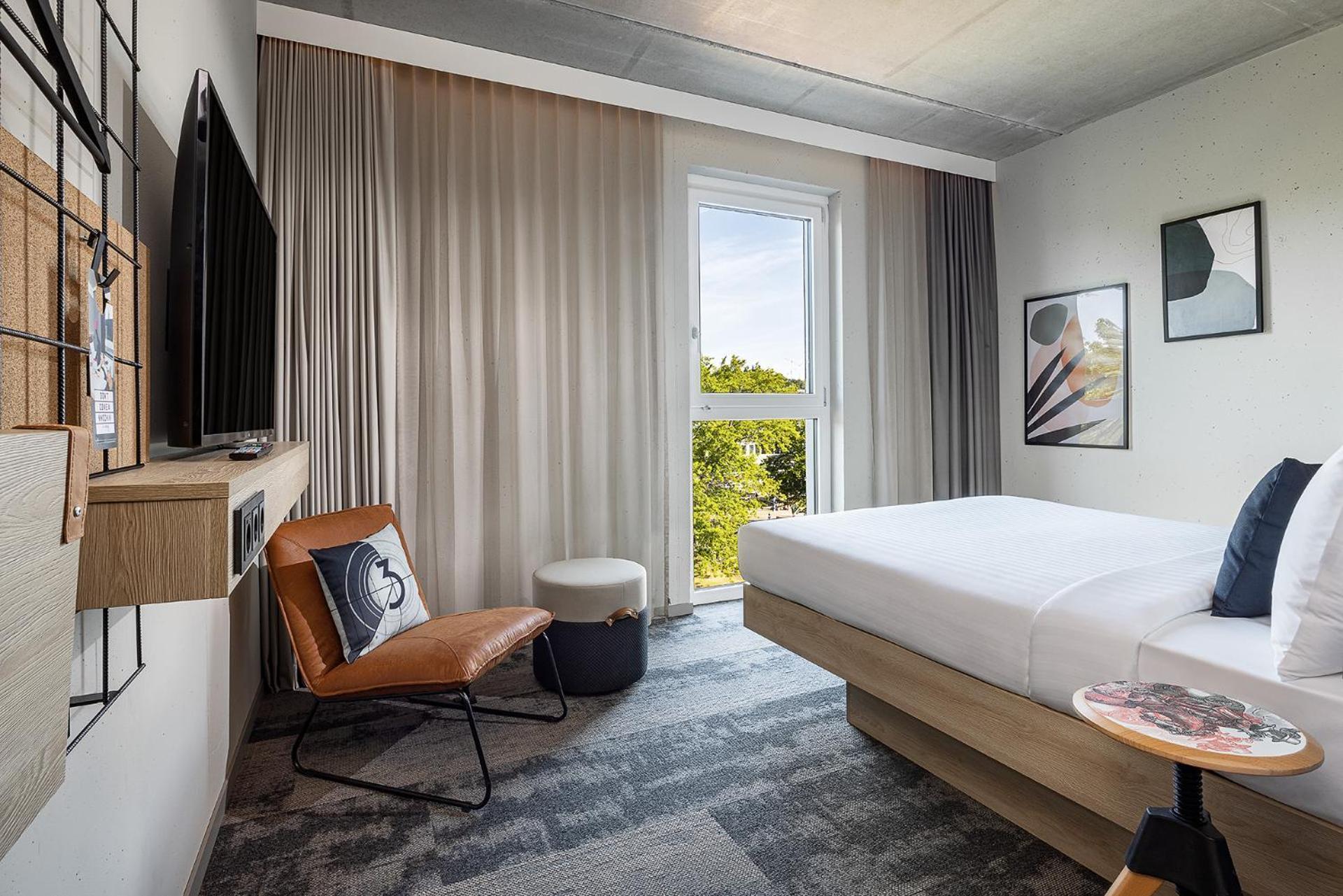 Zimmer Moxy mit Queensize-Bett und Stadtblick