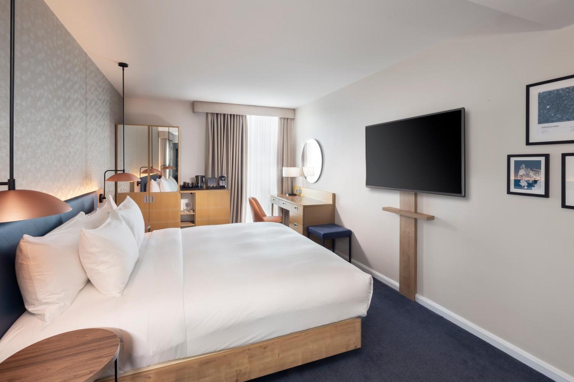 Habitación con cama grande y vistas al parque